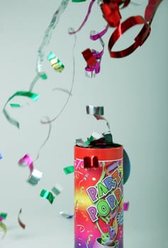 Colored confetti shooting up in the air from a party popper