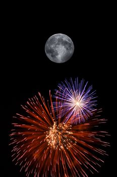 Full moon and fireworks exploding on clear night