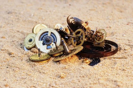 Detail (close-up) of the parts of clockwork mechanism on the sand