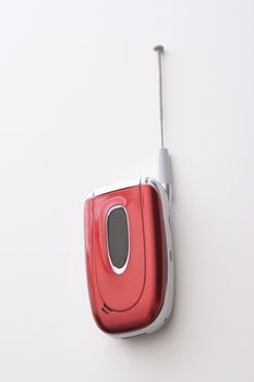 Red, black and silver cellular phone with extended antenna
