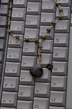 smokey quartz and gold necklaces on grey keyboard