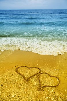 Drawing of two hearts in the sand on beach