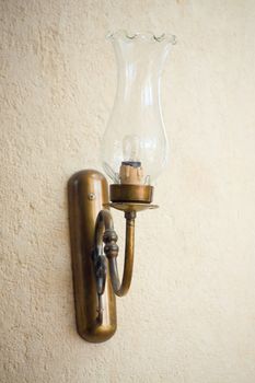 On the wall hangs a decorative lamp with a glass bulb.