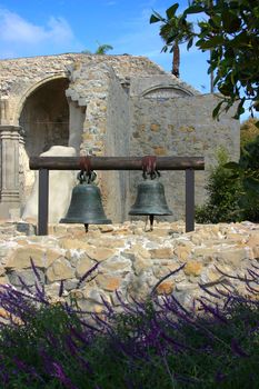 Two Bells hanging at Mission San Juan Capistrano with the ruins in the background.