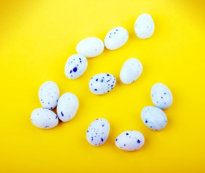 White easter eggs on yellow background.