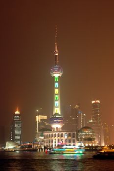 Shanghai city in China. Famous Orient Pearl TV tower with Huangpu River by night.