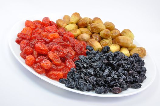 Dried Dates, Cornelian Cherries and Black Raisins on White Plate Isolated