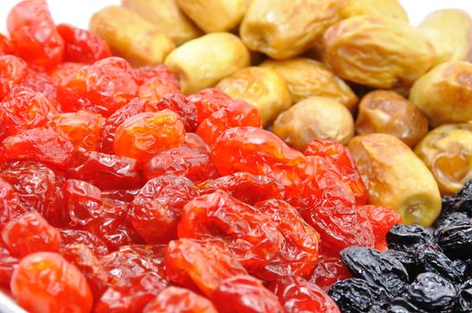 Dried Dates, Cornelian Cherries and Black Raisins on White Plate Isolated, Close-Up