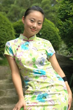 Charming Chinese girl smiling, wearing traditional dress.