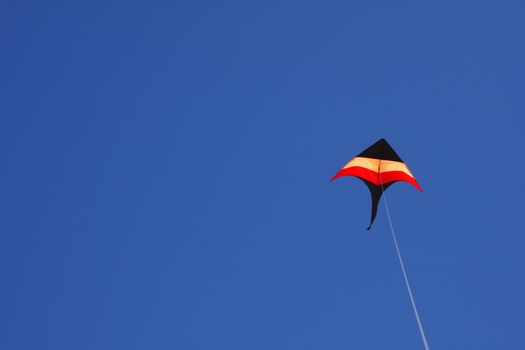 Colorful kite flying in a clear blue sky