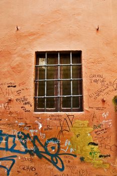 Italian window with iron bars and wall with graffiti