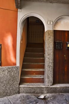Italian house entrance with staircase, arch and pigeon
