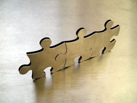 Metallic jigsaw puzzle pieces on a metallic background
