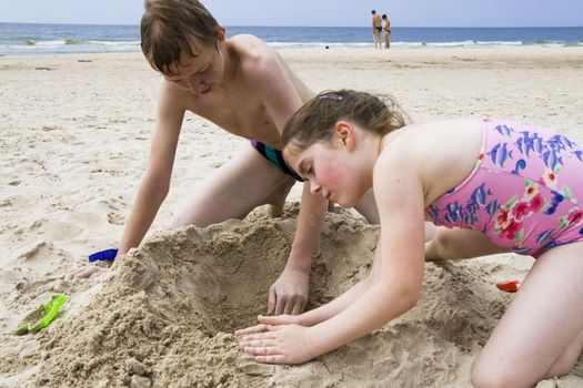 Brothe and sister playing at the beach of Baltic sea