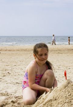 Happy girl playing in sand beach