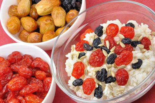 Three Bowls with Boiled Rice and Dried Fruit on Red Background