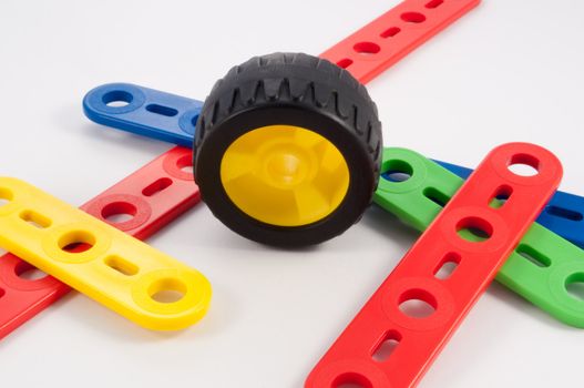 Close up capturing components from a child's plastic construction set arranged on white.