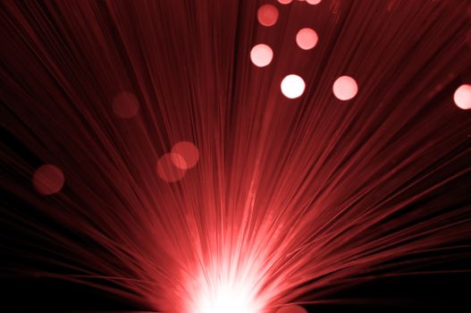 Close and low level abstract style capturing red fibre optic light strands.