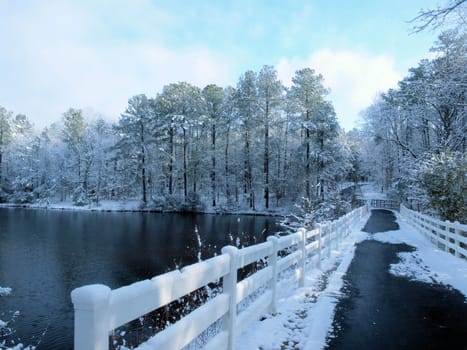 A bridge over a lake during the winter time.