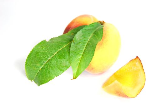 ripe peach fruit with green leafs isolated on white