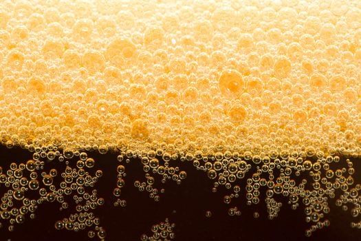 close-up appetizing filtered dark beer with foam