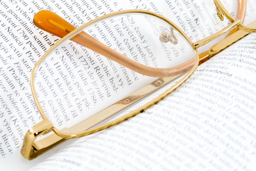 glasses lying on an open book - close up