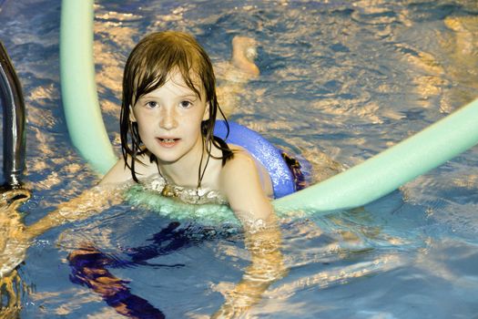 The girl, floats in pool with a life buoy