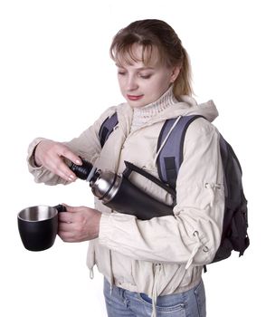 Pretty girl in a jacket with the hood holding thermos bottle and caps