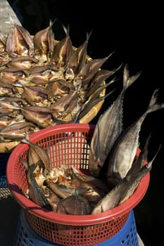 freshly caught fish drying in baskets in thai marketplace