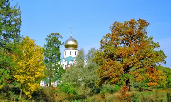 Autumn landscape with church in sunny day