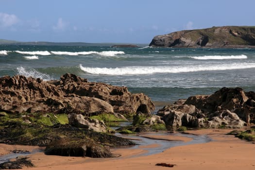 a rocky beach on a warm day with a calm sea an ideal place to have a walk in ireland