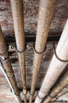 Angled view of old, rusty industrial pipes along ceiling