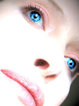 The close-up of a womans face with enhanced blue eyes.