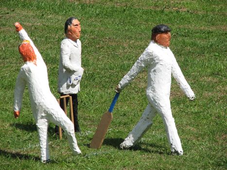 Model cricket players on grass background