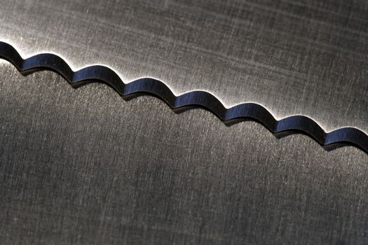 Macro image of a serrated kitchen knife.
