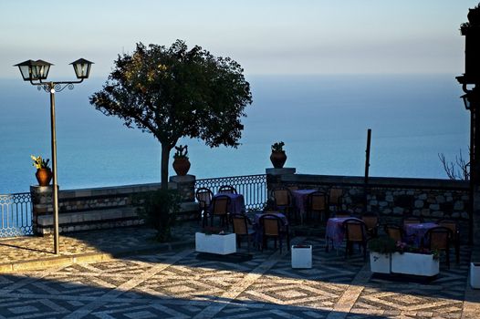 Terrace overlooking Mediterranean sea with coffee tables and shade