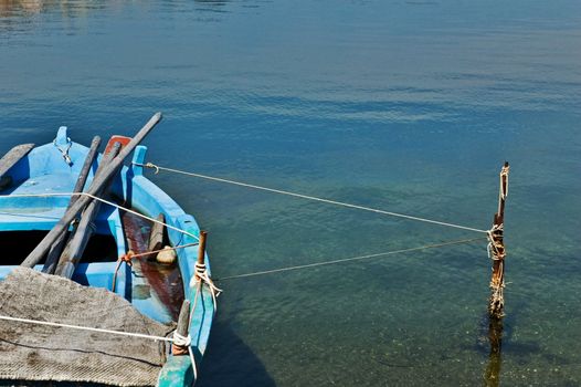 Fisherman's boat tied up to pole with copy space