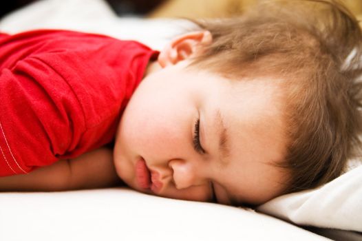 Boy in red dress sleeping on bed (napping)