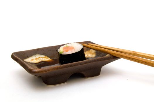 Salmon roll with avocado in soy lying on plate isolated om white