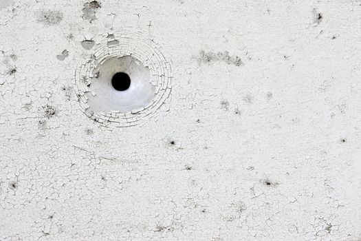 White peeling paint aluminium plate with bullet hole