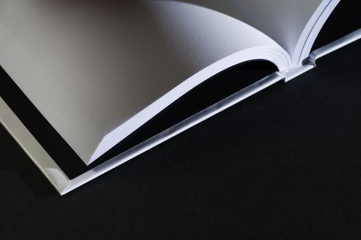 Closeup of an open blank book in black background