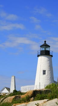 at the top of granite ledge stands the Pemquid Point Lighthouse in Maine