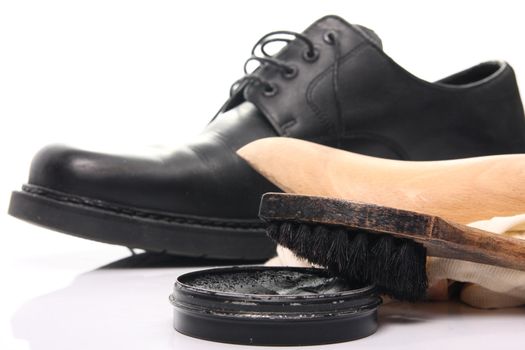 shoe care equipment and formal black shoe on white background