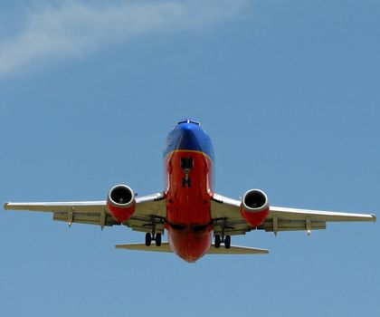 A 737 plane with the landing gears down.
