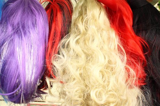 Colorful wigs for camouflage for carnival in a retail store on the street