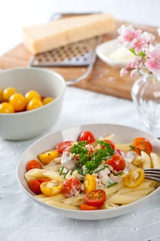 Delicious pasta dish with cherry tomatoes, parsley and pinenuts