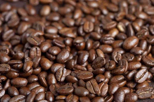 Pile of roasted coffee beans looking dark and lovely