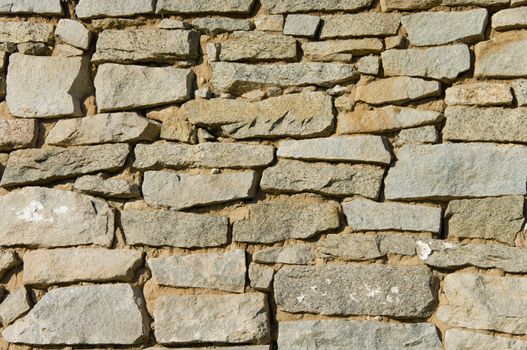 Old stone wall background shot in direct sunlight