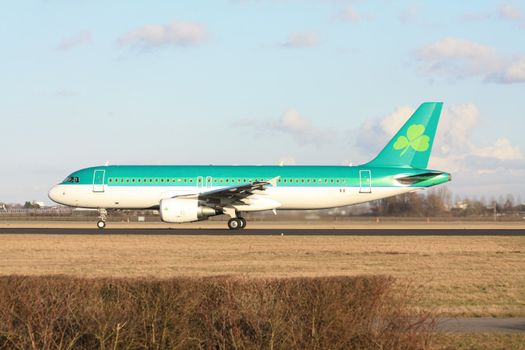 A green passenger airliner on the runway, preparing for take off