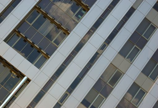 front of new modern office building with reflections of clouds